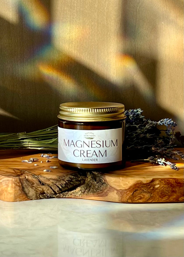 Jar of Natural Northern magnesium cream  for restless legs on a wooden surface with lavender flowers