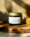 Jar of Natural Northern's Wisconsin 'whipped Tallow' on a wooden surface with a blurred background