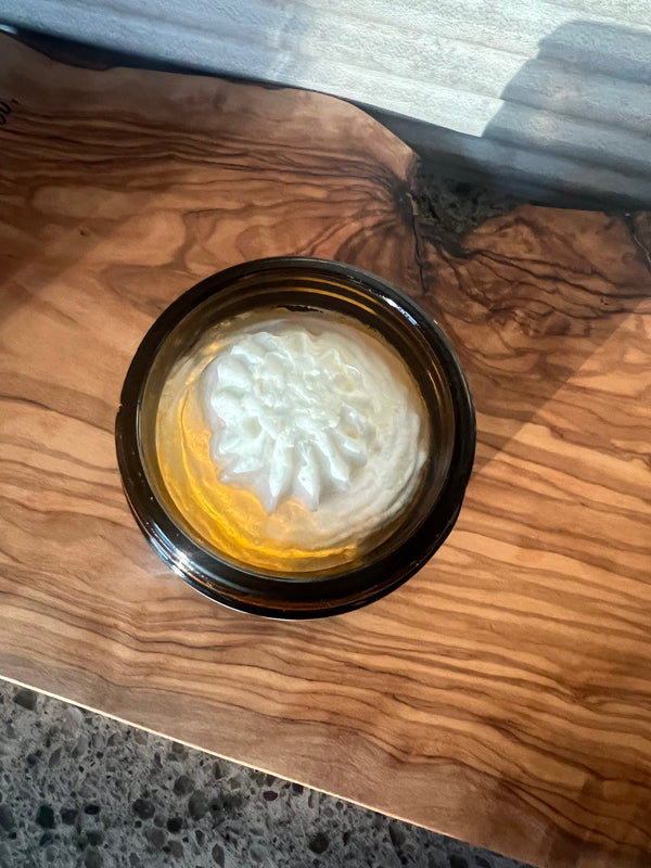 Small container of Natural Northern's Whipped tallow in a amber glass jar on a wooden surface