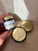 Kim Laureano founder of Natural Northern in Minocqua, WI holding a bestselling Limited Edition 1oz mini amber jar of Winter Cream for dry sensitive skin. The Mini Jar is shown with a 2oz glass amber jar of Winter Cream, with a light but rich creamy texture. 
